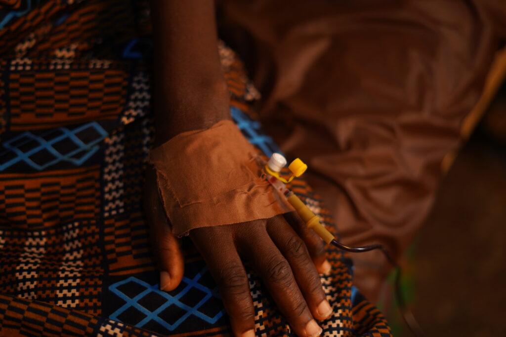A woman with a cannula in her hand receives a blood transfusion.
