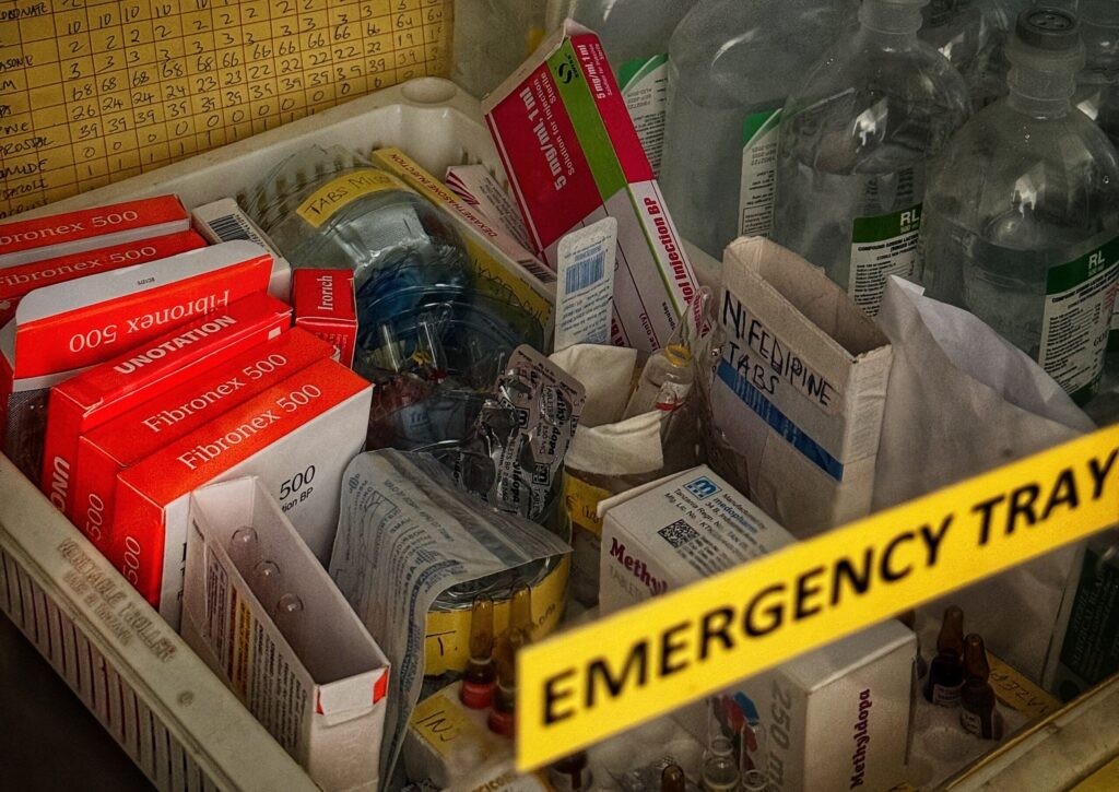 A tray containing boxes of medications in a hospital ward