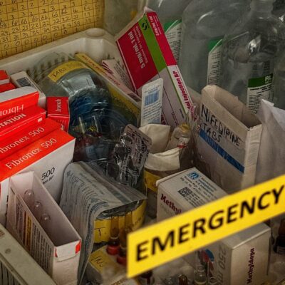 A tray containing boxes of medications in a hospital ward.