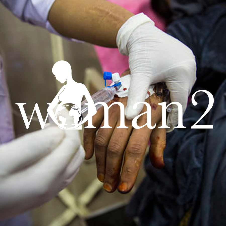 A close-up of a gloved medical professional holding a patient’s hand, with the text overlay 'Woman2.'