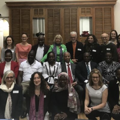 A diverse group of people posing for a formal group photo indoors, indicating a professional or educational event